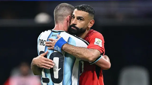 Mohamed Salah of Egypt and Alexis Mac Allister of Argentina embrace at full-time