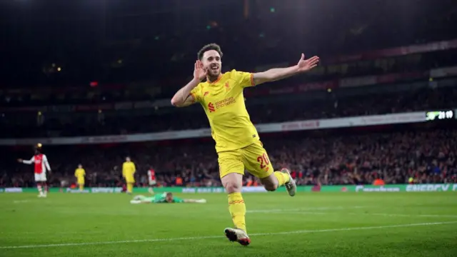 Diogo Jota celebrates a goal against Arsenal in a yellow Liverpool kit