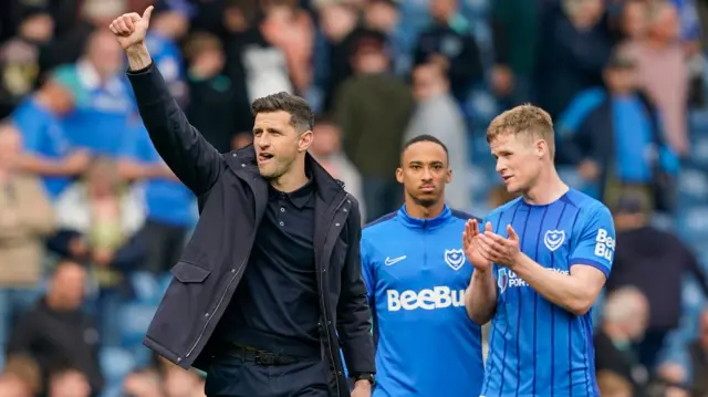 Portsmouth boss John Mousinho puts his thumbs up to the supporters at Fratton Park and defender Rob Atkinson applauds after the 2-2 draw with Derby