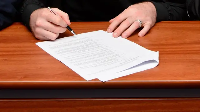 A general image of a footballer signing a contract