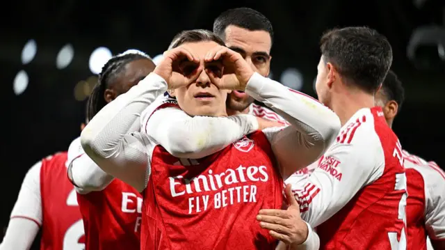 Leandro Trossard - surrounded by team-mates - cups his hands around eyes in celebration of goal against Tottenham