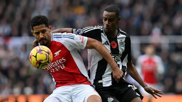 William Saliba of Arsenal FC (2) shields the ball from Alexander Isak of Newcastle United (14) during the Premier League match between Newcastle United FC and Arsenal FC at St James' Park