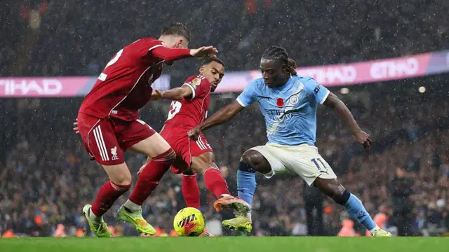 Jeremy Doku of Manchester City battles for possession with Ryan Gravenberch and Conor Bradley