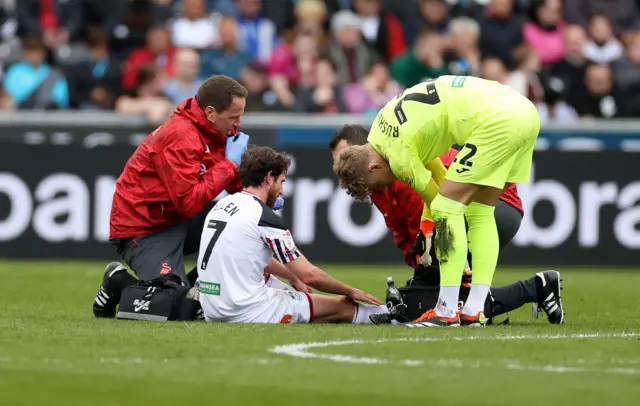 Joe Allen is treated during Swansea's defeat to QPR