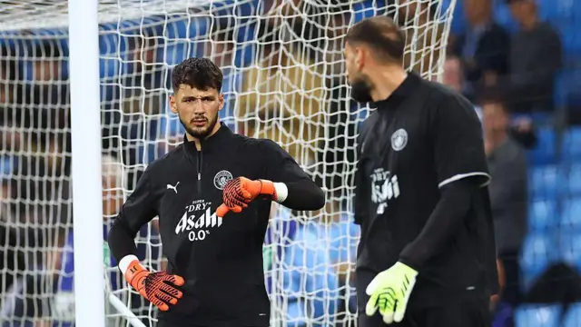 James Trafford of Manchester City speaks to teammate Gianluigi Donnarumma during the warm up