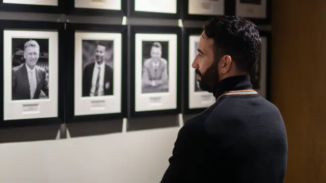 Ruben Amorim looking at a picture of former Manchester United managers