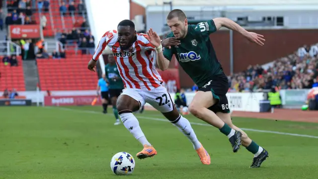 Stoke City's Junior Tchamadeu and Watford's Giorgi Chakvetadze battling for the ball with the crowd in the background