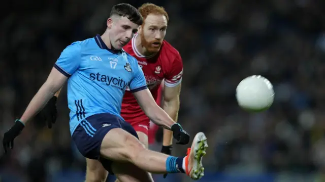 Eoghan O'Donnell kicks a Dublin point despite Conor Glass' efforts