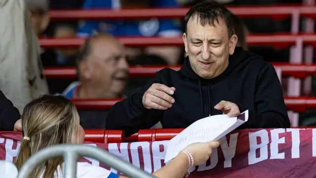 Tony Bloom - Brighton chairman - is handed a teamsheet
