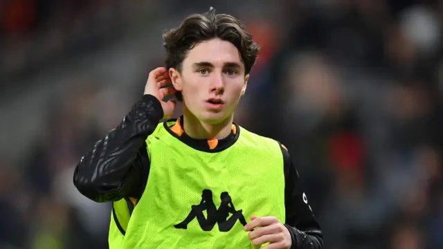 Rocco Coyle scratches the back of his head while wearing a bib over his Hull City kit