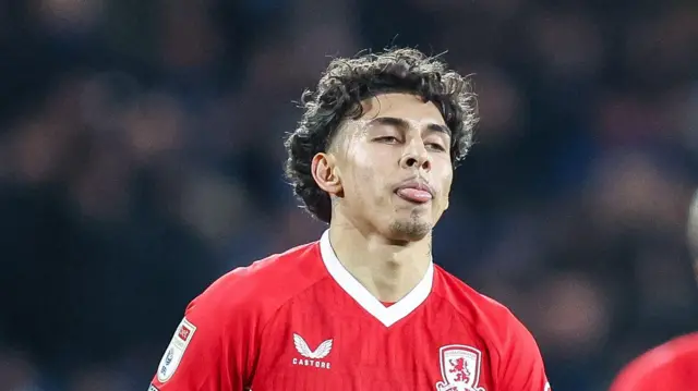 A close-up of Jeremy Sarmiento with his tongue out while wearing a Middlesbrough home shirt