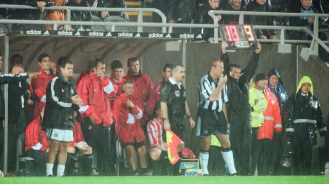 Alan Shearer is brought on from the bench at a rain-soaked St James' Park in August 1999