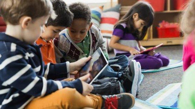 Young children looking at tablets