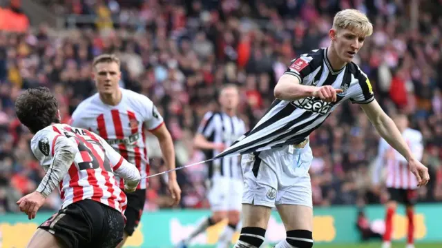 Newcastle player Anthony Gordon has his shirt ripped by Sunderland player Trai Hume