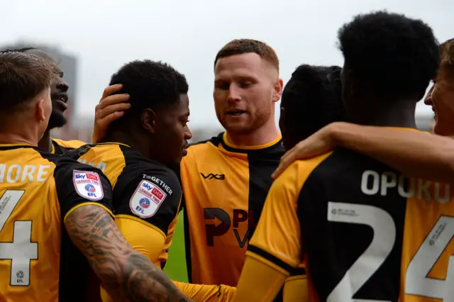 Seven Newport County players huddle following Nathan Opoku's goal against Gillingham.