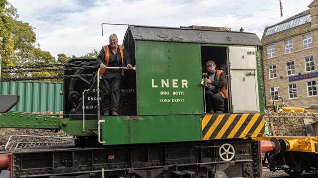 KWVR volunteers Keith and Margret Bonner use the 10-tonne green Grafton Crane to lift railway track into place