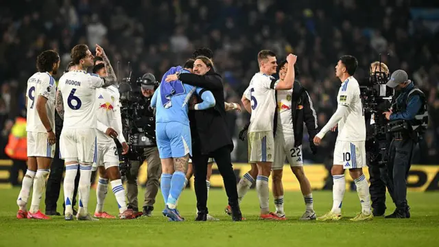 Daniel Farke embraces Leeds goalkeeper Lucas Perri as he celebrates with his players