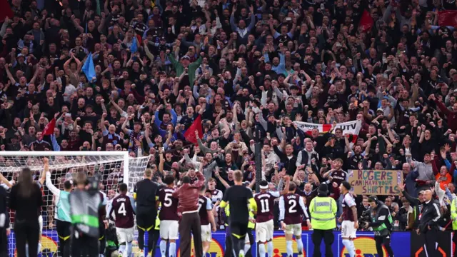 Fans of Aston Villa celebrate with the team