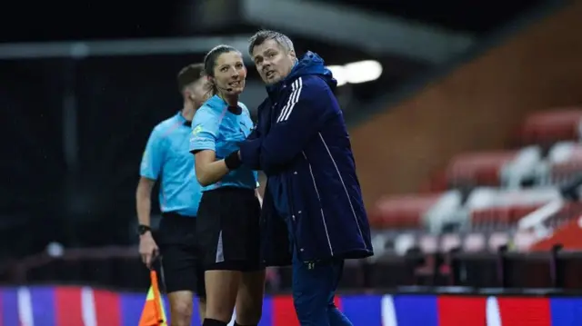Referee Melissa Burgin explains to Newcastle coach Robbie Stockdale why she has stopped the Premier League 2 clash with Manchester United at Leigh Sports Village
