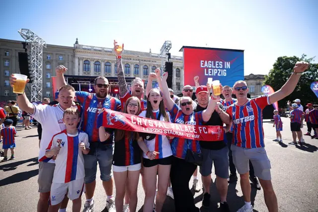 Fans pose with a Crystal Palace scarf in Lepizig