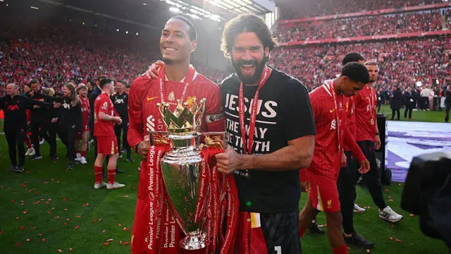 Virgil van Dijk and Alisson Becker of Liverpool celebrate with the Premier League trophy,