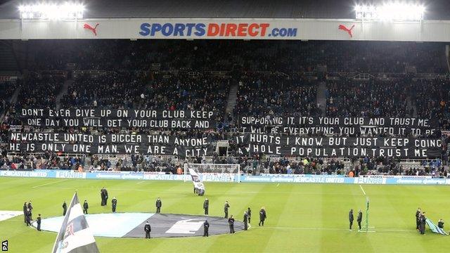 Newcastle United fans unveil a banner at their home game with Burneley