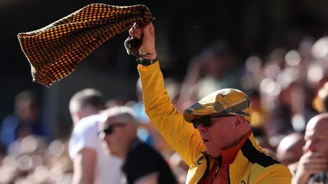 A supporter of Wolverhampton Wanderers waves his scarf