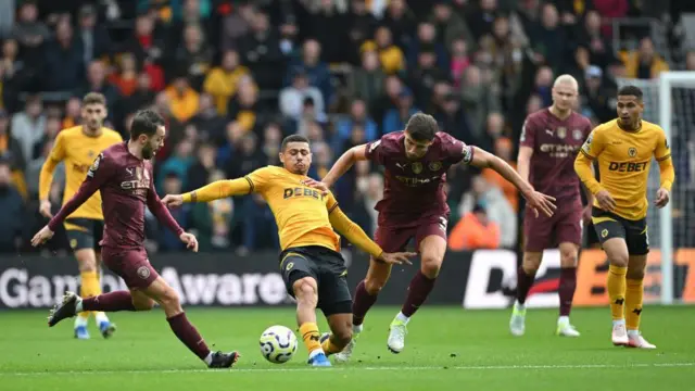 Bernardo Silva, Andre and Ruben Dias contest for the ball at Molineux