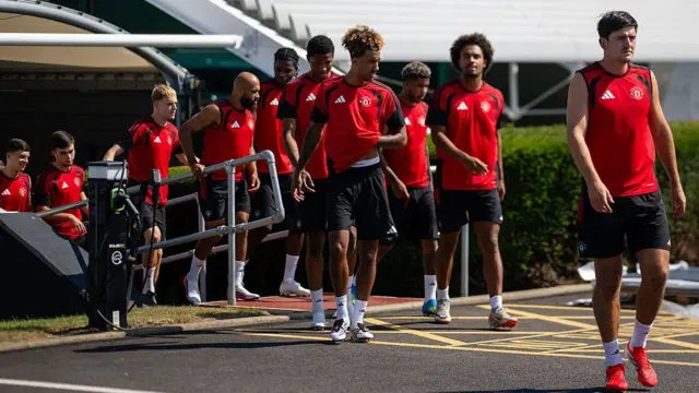 Harry Maguire leading the Manchester United squad out for training at Carrington