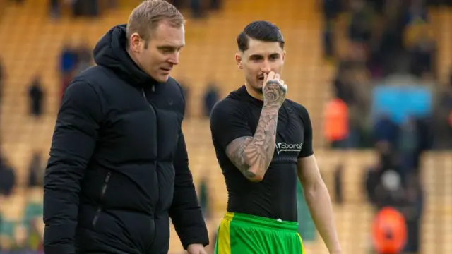 Norwich City boss Johannes Hoff Thorup talks to striker Borja Sainz as they walk along the touchline