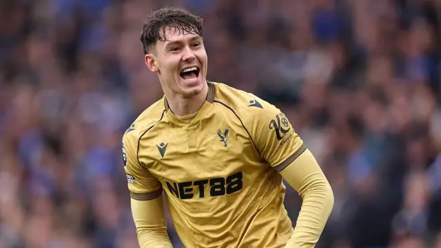 Jorgen Strand Larsen playing in Crystal Palace away colours. He smiles broadly.