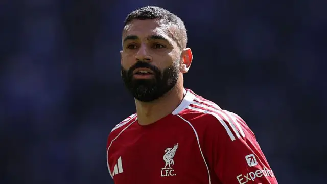 Mo Salah of Liverpool in a red Liverpool kit with white details.