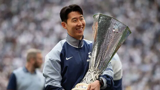Son Heung-min holding the Europa League trophy