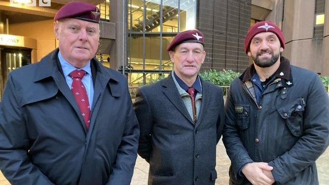 Three ex-paratroopers, wearing red berets, stand outside Liverpool Crown Court 