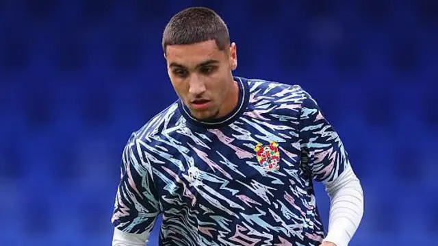 Taylan Harris in a multi-coloured Tranmere Rovers shirt.