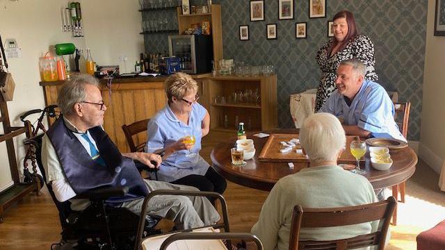 Carers and residents sat around a table in the pub