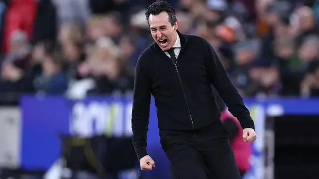 Unai Emery shouts in celebration and clenches his fists by his side during game at West Ham