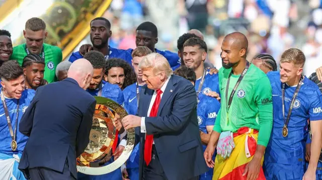 Fifa president Gianni Infantino and US President Donald Trump hand over the Club World Cup trophy to Chelsea captain Reece James