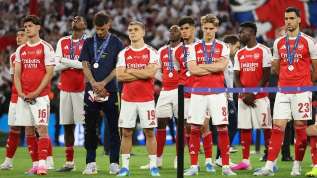 Arsenal players stand with medals