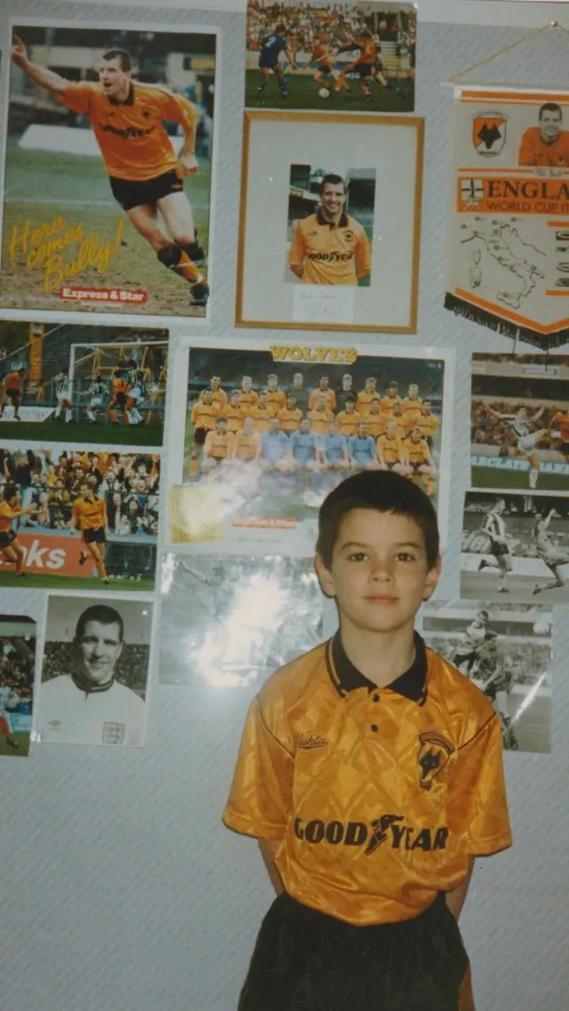 Alex as young Wolves fan in front of a board of photographs