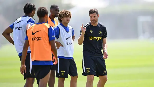 Xabi Alonso pointing in the air while talking to multiple players