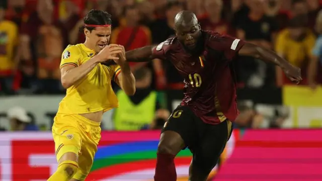 Ianis Hagi tussles with Belgium striker Romelu Lukaku in Romania's 2-0 defeat