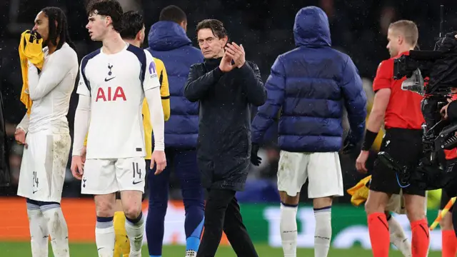 Thomas Frank applauds amid a crowd of players on the pitch