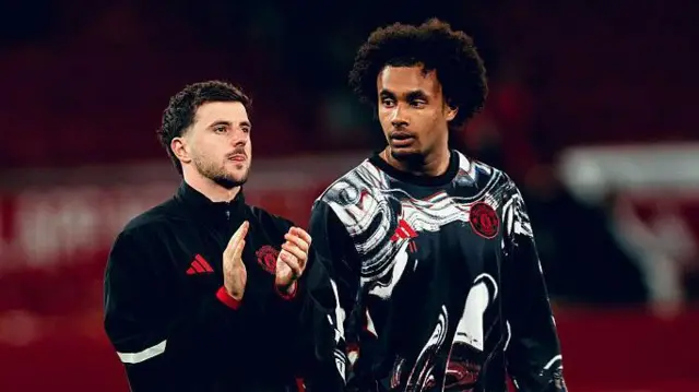Mason Mount and Joshua Zirkzee of Manchester United walk off the Old Trafford pitch in training gear