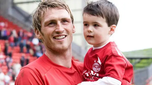 Former Aberdeen striker Lee Miller holds young son Lennon in 2009