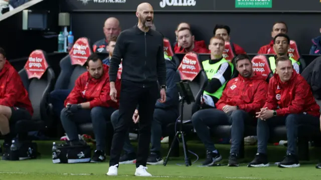 Luke Williams shouts instructions to players while standing in front of the Swansea dugout