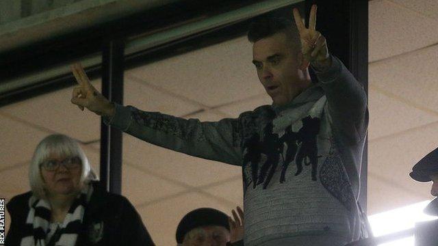 Singer-songwriter and Port Vale fan Robbie Williams acknowledges the crowd during a game at Vale Park this season. Williams is playing a charity concert at the venue in June 2020