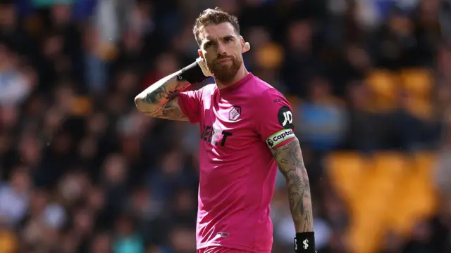 Jose Sa wearing his pink goalkeeping kit and captain's armband for Wolves in the Premier League last season