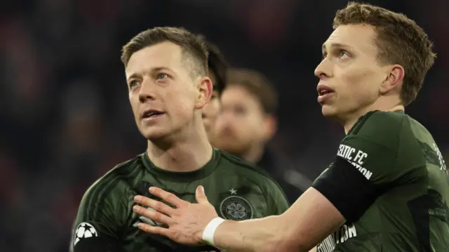 Celtic's Alistair Johnston and Callum McGregor at Full Time during the UEFA Champions League 2024/25 League Knockout Play-off second leg match between FC Bayern Munich and Celtic at the Allianz Arena