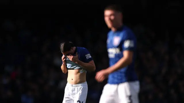 Jacob Greaves covers his face with his shirt